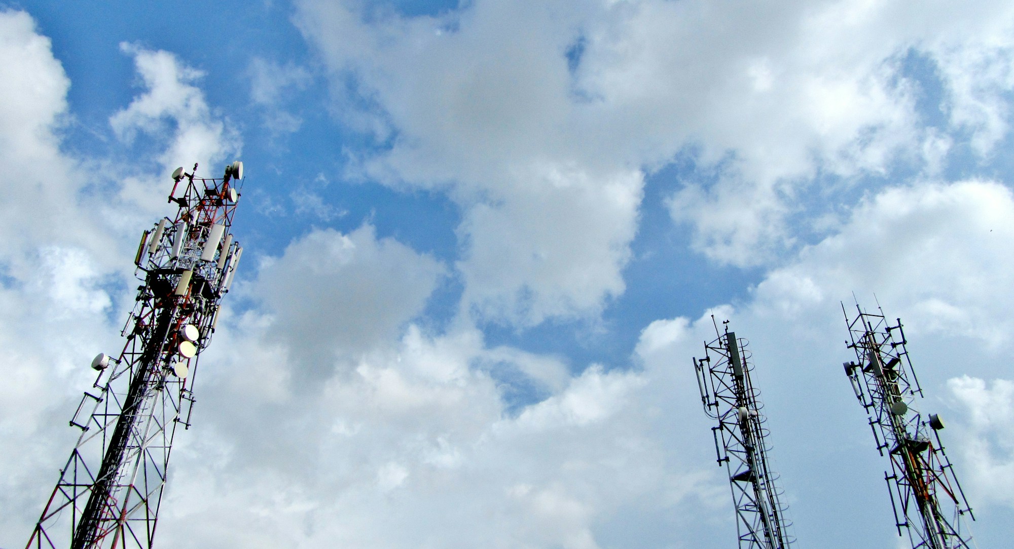 5G abone sayısı haberi için temsili görsel: bulutlu gökyüzünde mobil iletişim kuleleri