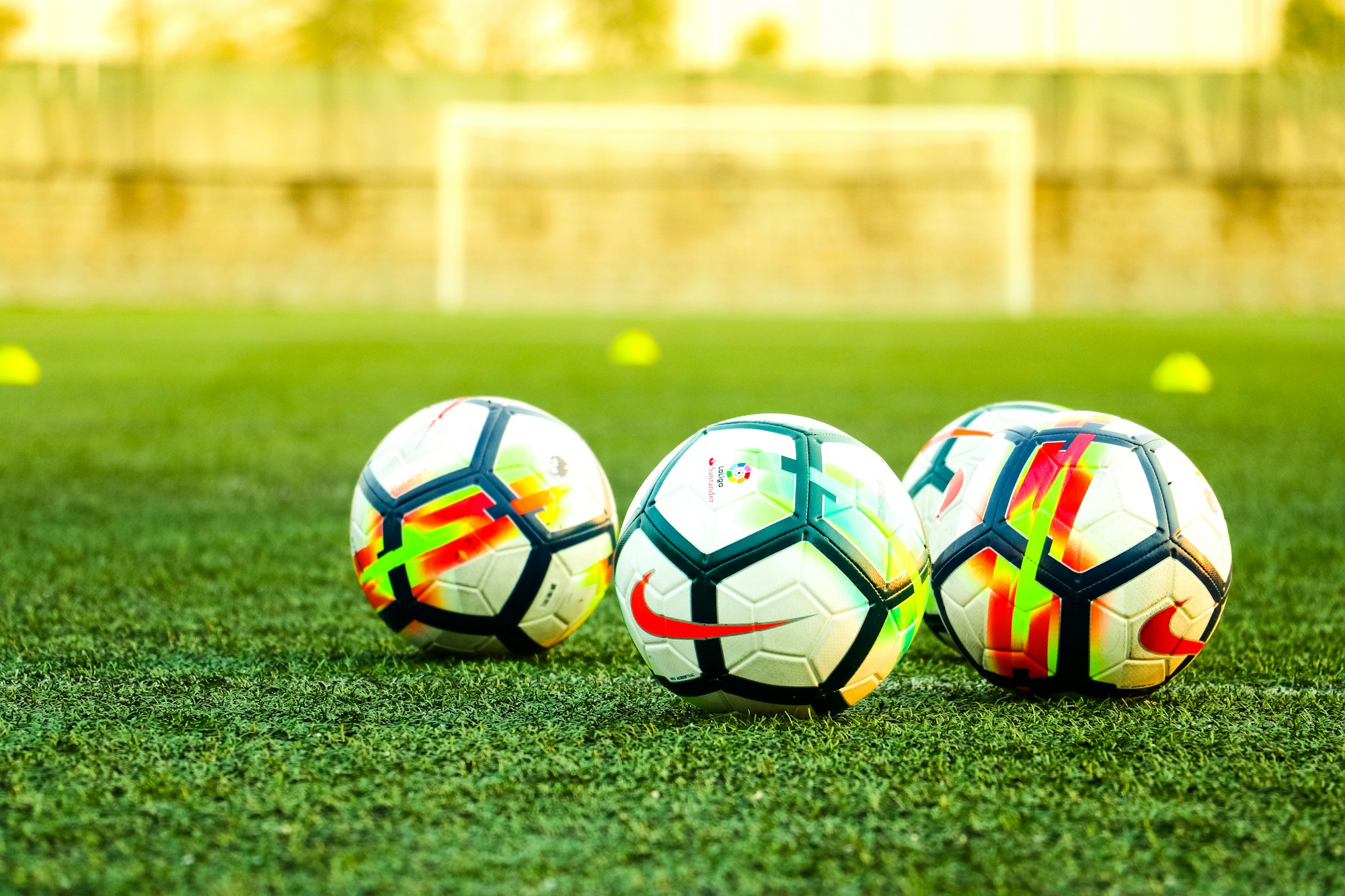Çimde üç adet siyah-beyaz futbol topu
