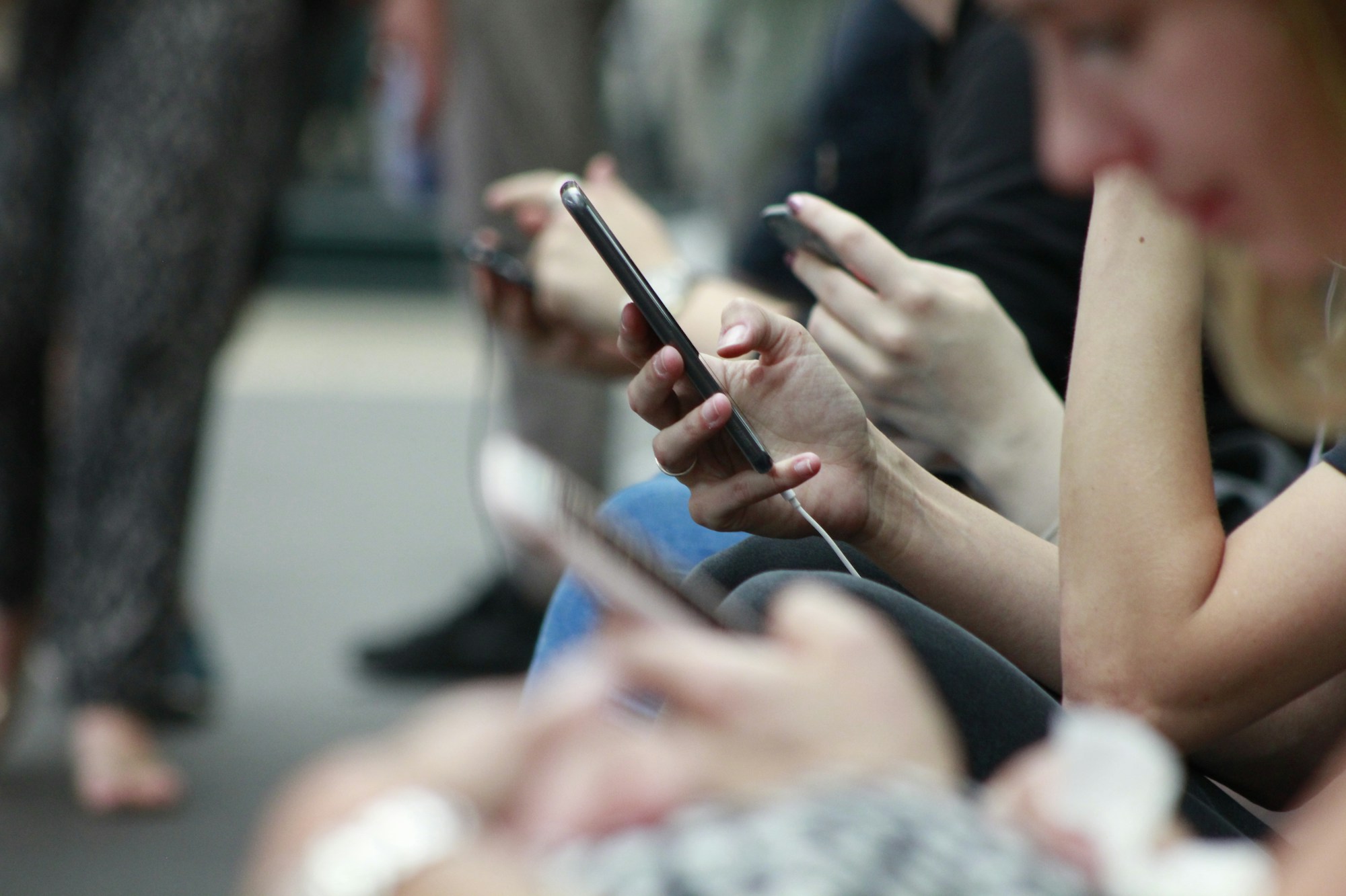 Ellerindeki akıllı telefonlara bakan kişiler