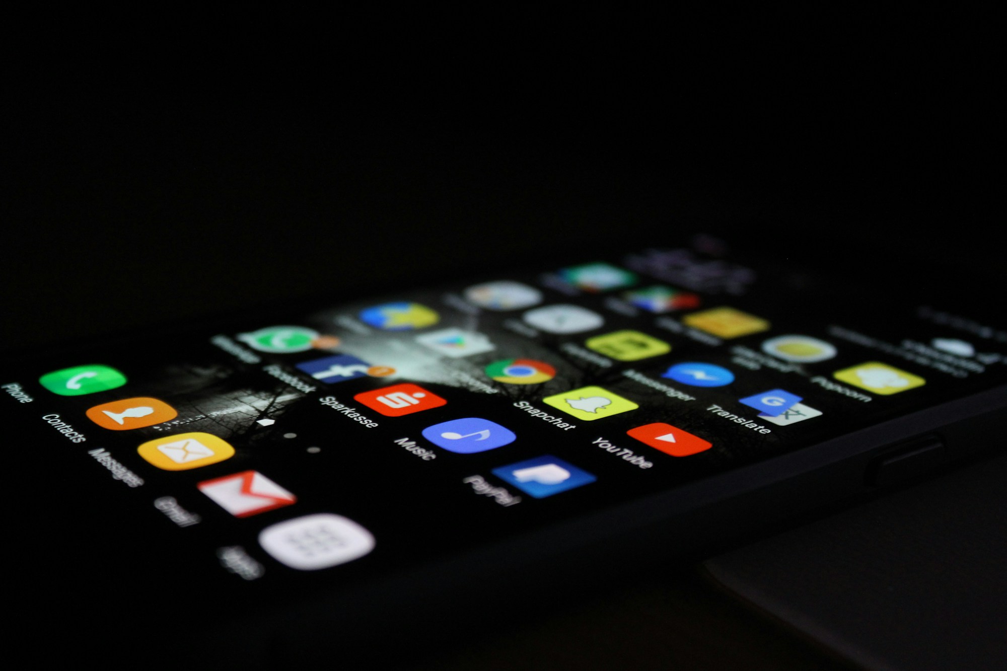 Karanlıkta ekranında uygulama simgeleri görünen telefon