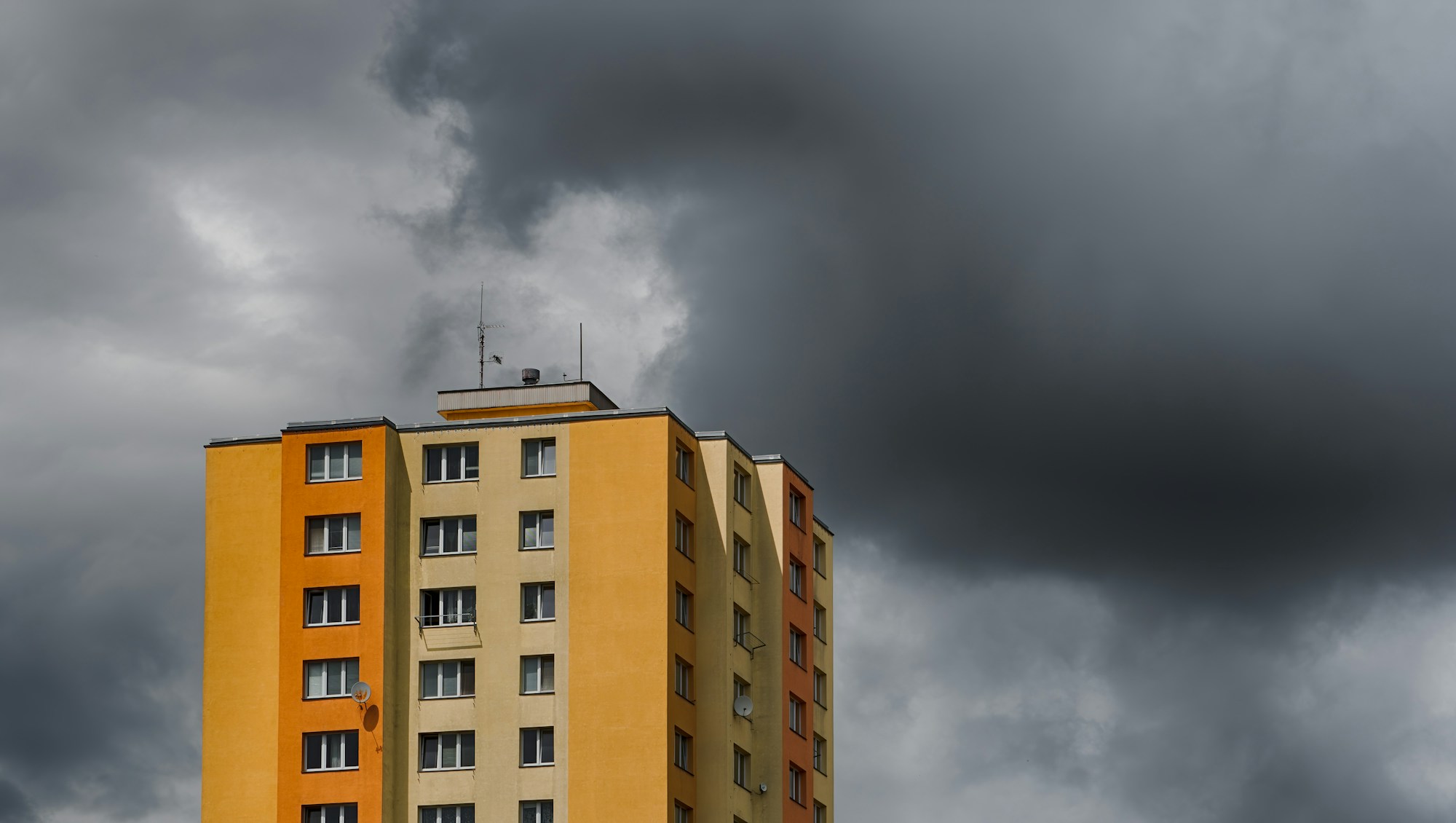 Koyu bulutların altında yüksek bir apartman