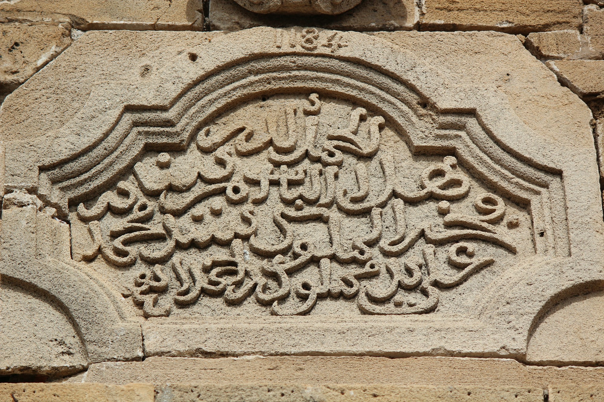 Taş üzerine oyulmuş Arap harfli bir kitabe ve bezeme (temsilî)