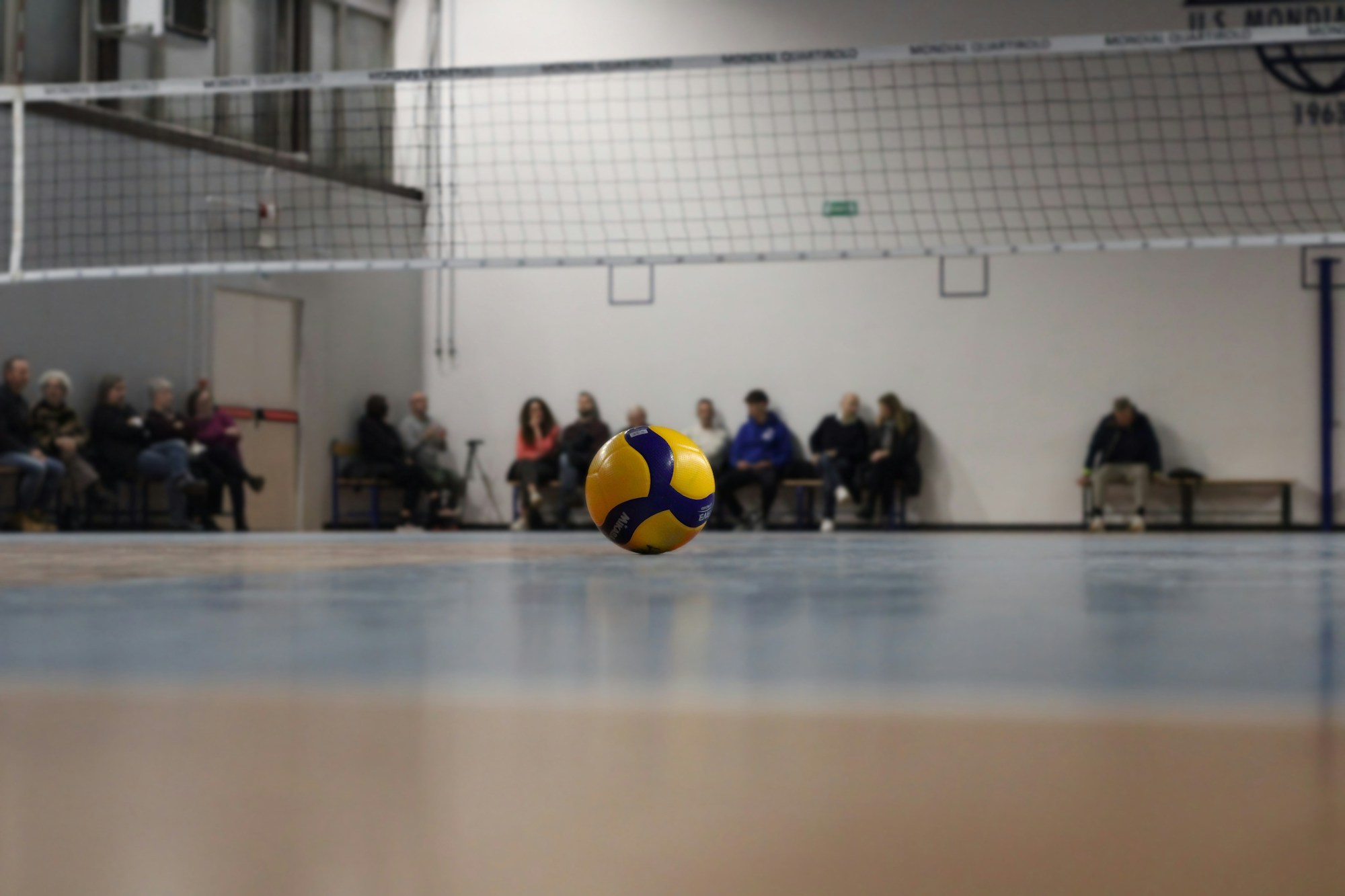 Kapalı salonda parkede duran bir voleybol topu