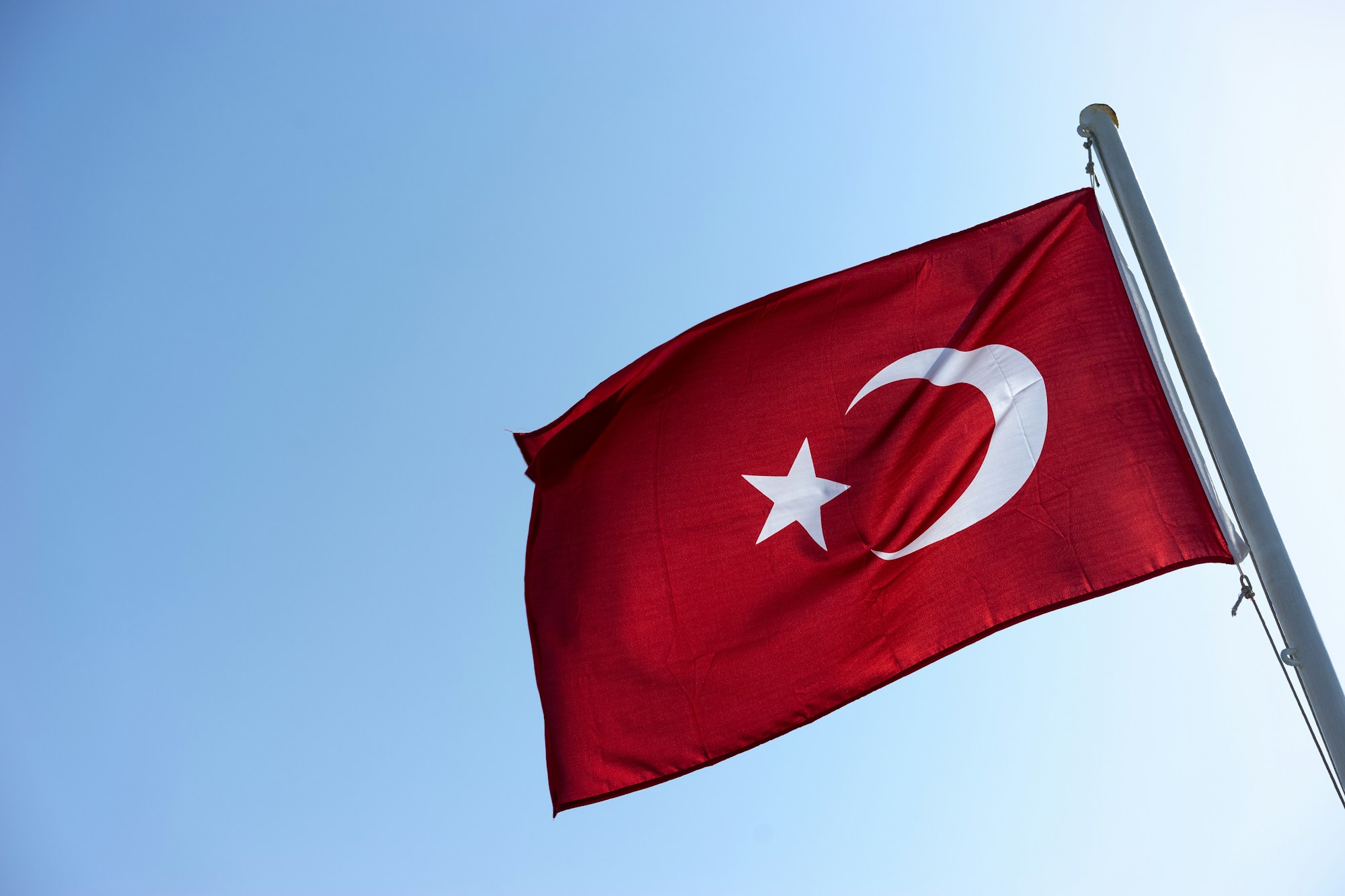 Gökyüzü önünde gönderde dalgalanan Türk bayrağı
